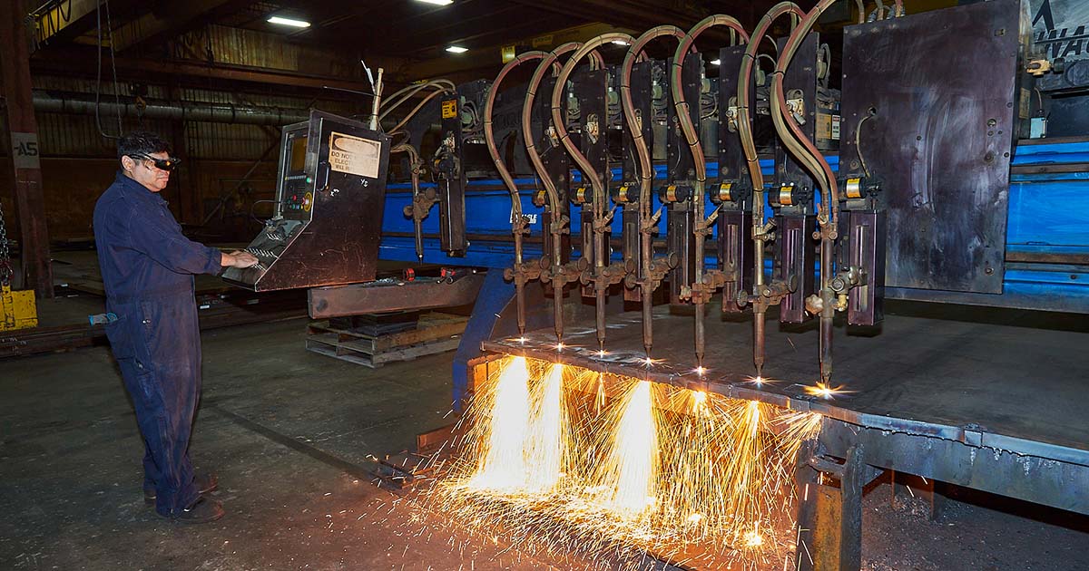 Worker operating a flame cutting machine.